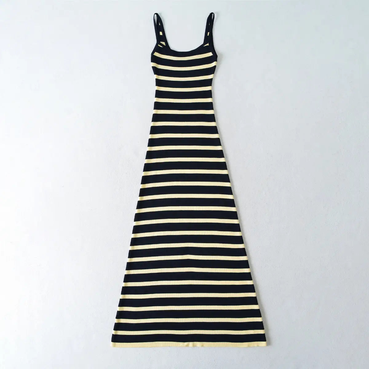 Flat lay view of a navy and pale yellow striped ribbed knit maxi dress, showing the full form-fitting silhouette.