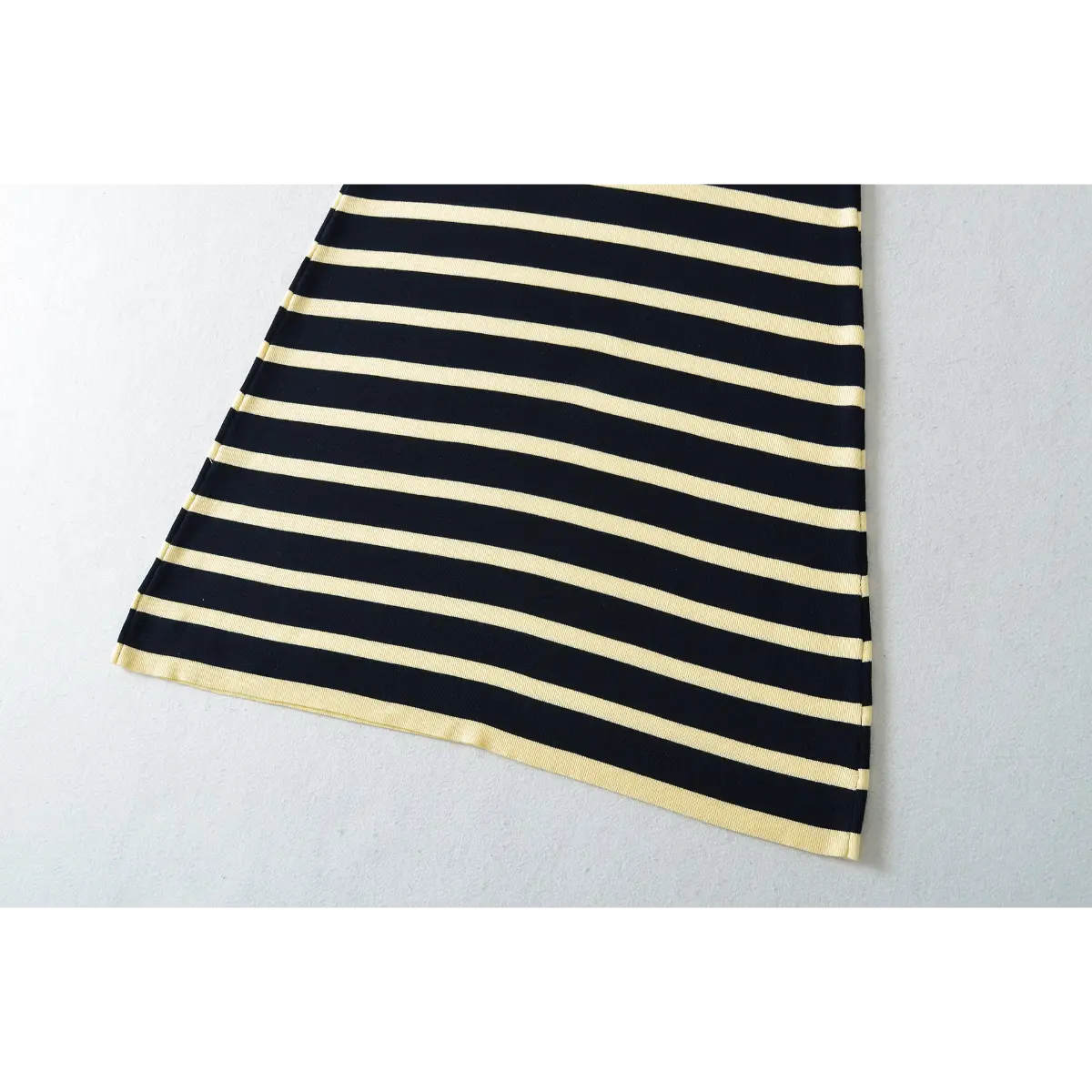 Close-up detail of the wide straps on a navy and pale yellow striped ribbed knit maxi dress.