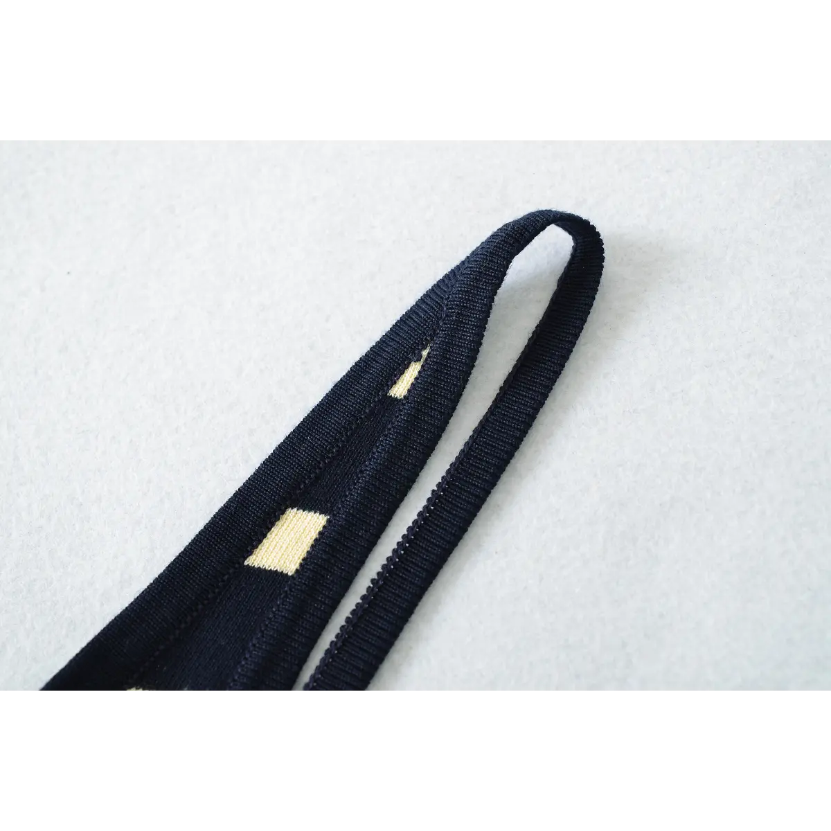 Close-up detail of the wide straps on a navy and pale yellow striped ribbed knit maxi dress.