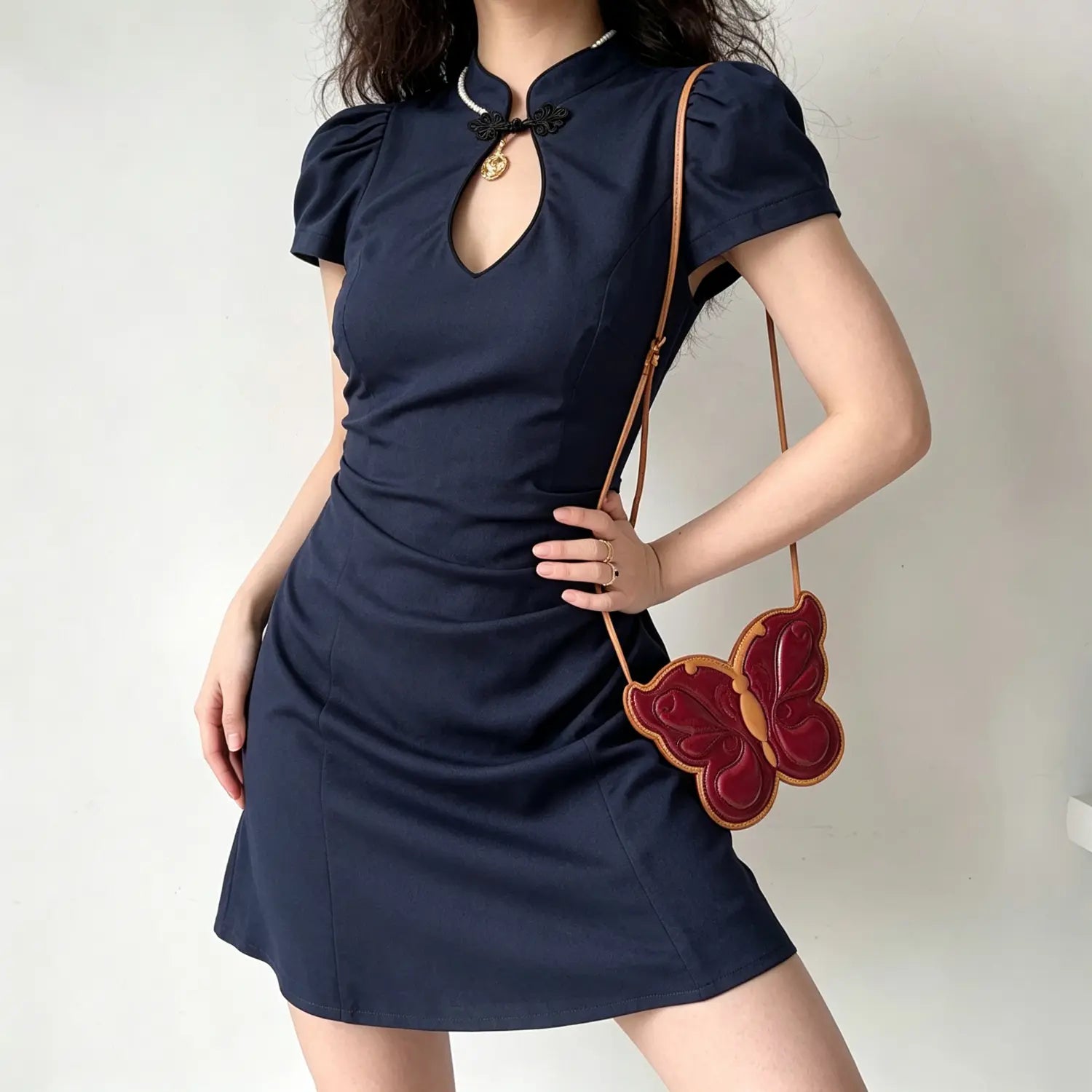 Model wearing navy blue new chinese qipao mini dress, puff short sleeve, side ruched silhouette