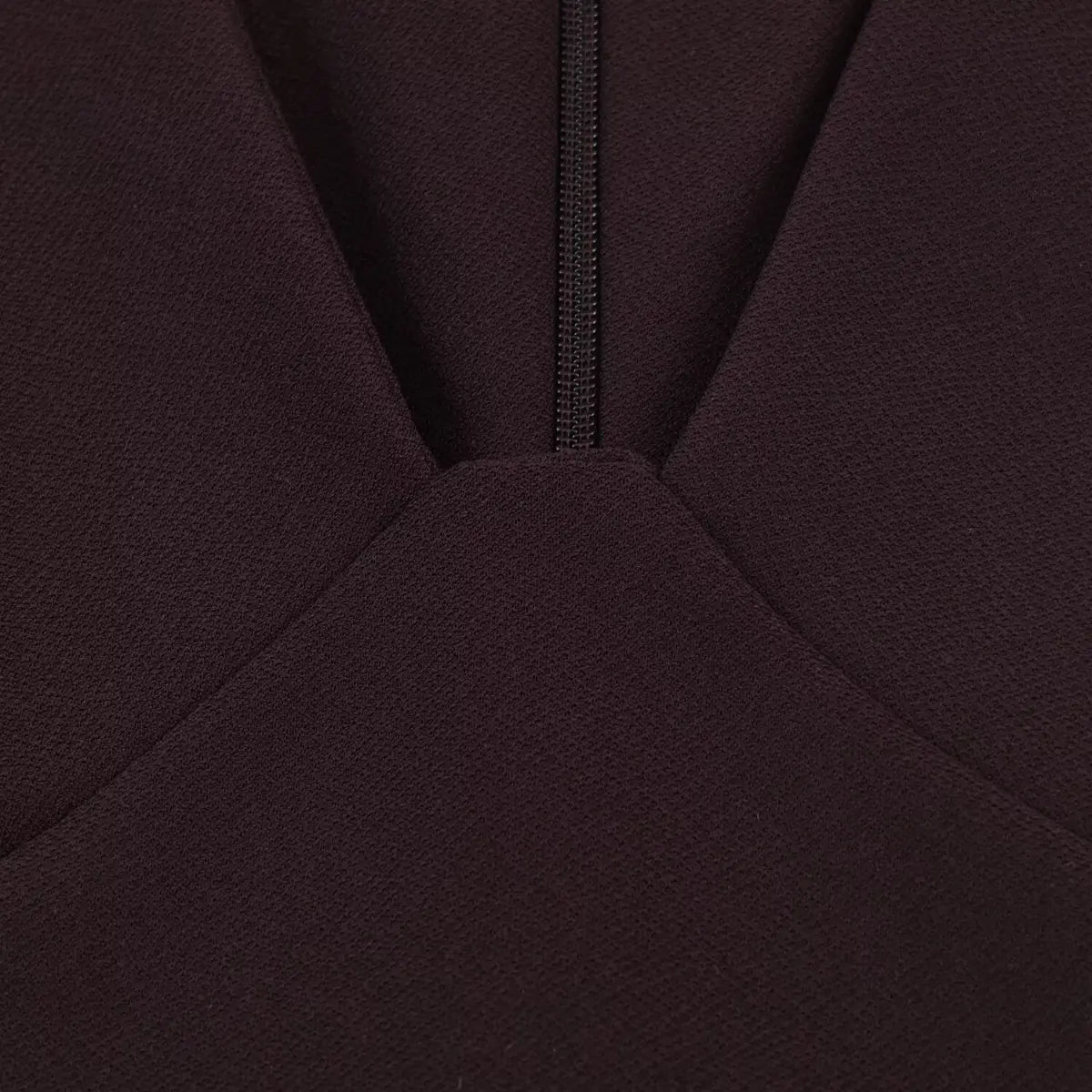 Close-up of the deep V-neckline and hidden zipper on a brown cap sleeve dress, highlighting the structured bust design.
