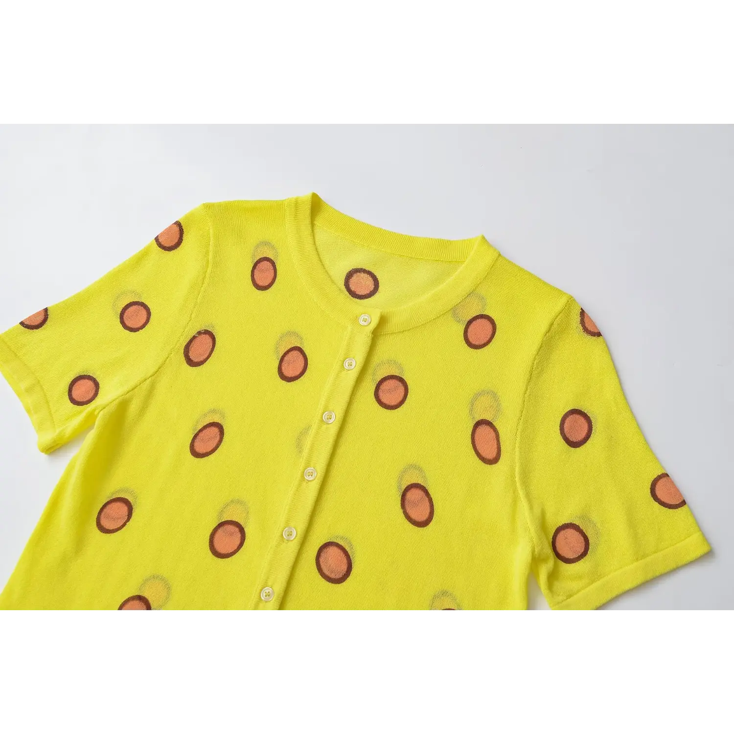 Neckline partial close-up, round rib neck, front shell buttons, yellow orange polka dot thin knit texture