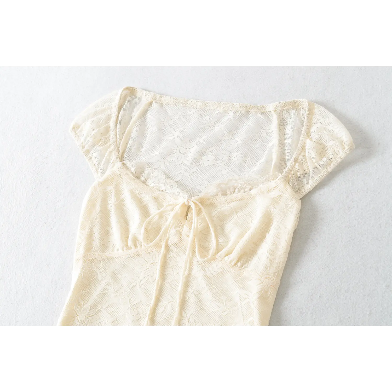 Square neck front drawstring tie lace macro close-up, wavy lace neck trim matching fabric wide adjustable tie to form bow dense full lace stitching bust shaping craft shot