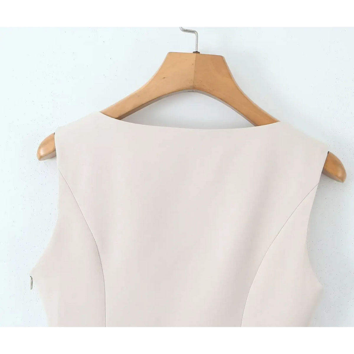 Close-up of ivory back neckline hanging on hanger