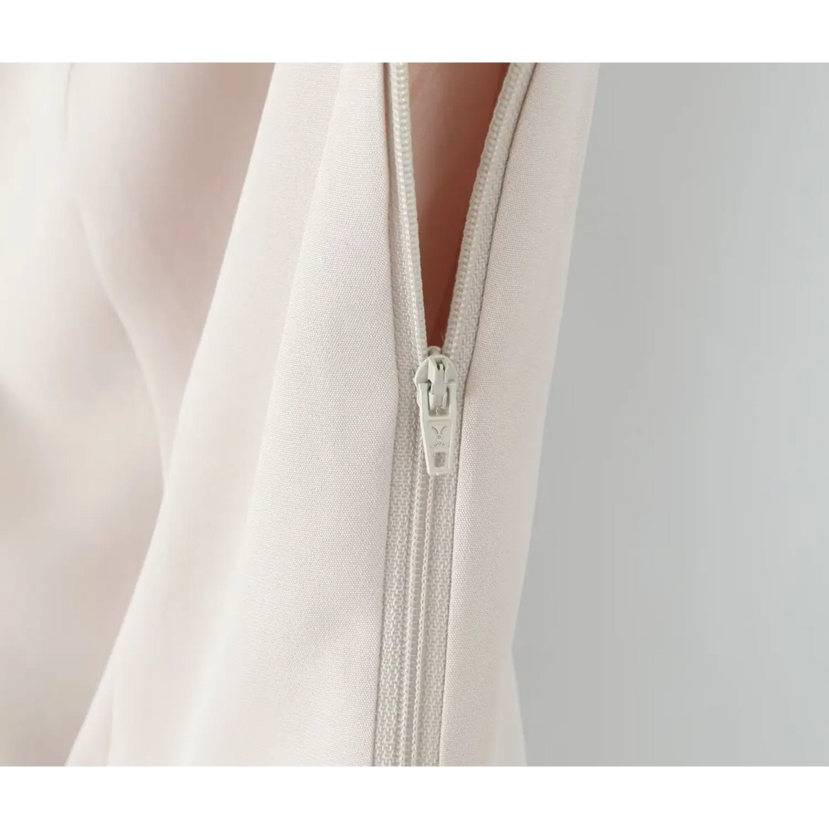 Close-up of ivory zipper pull detail