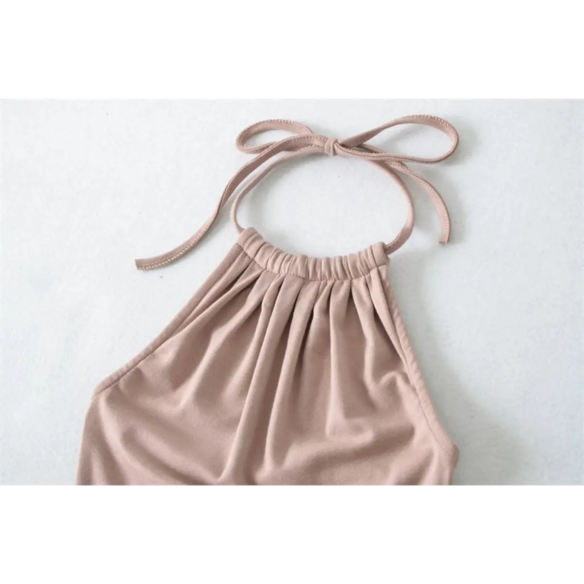 Close-up back view of the halter neckline on a nude mermaid maxi dress, showing the tied bow straps and elasticated top.