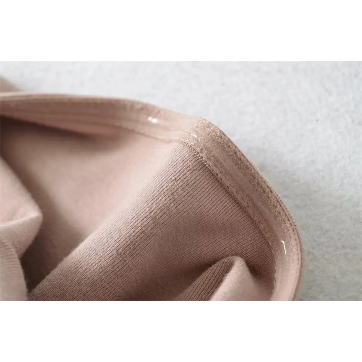 Close-up detail of the interior seam and fabric texture on a nude halter-neck mermaid maxi dress.