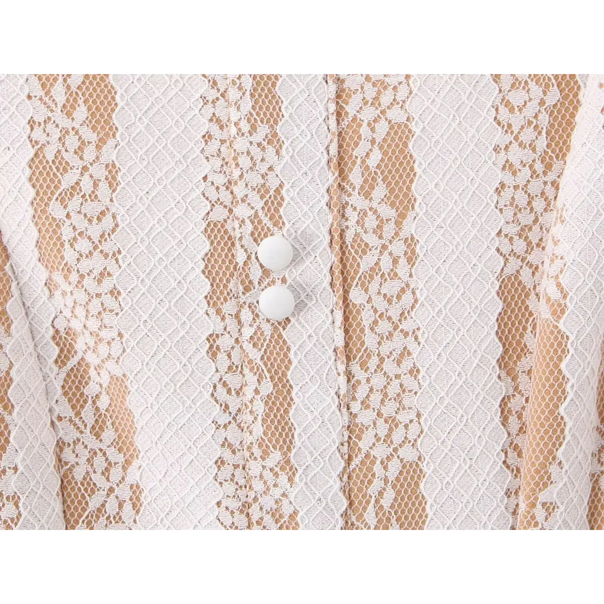 Close-up shot of the white decorative buttons on the front of a nude lace striped mini dress, highlighting the lace pattern and stitching.