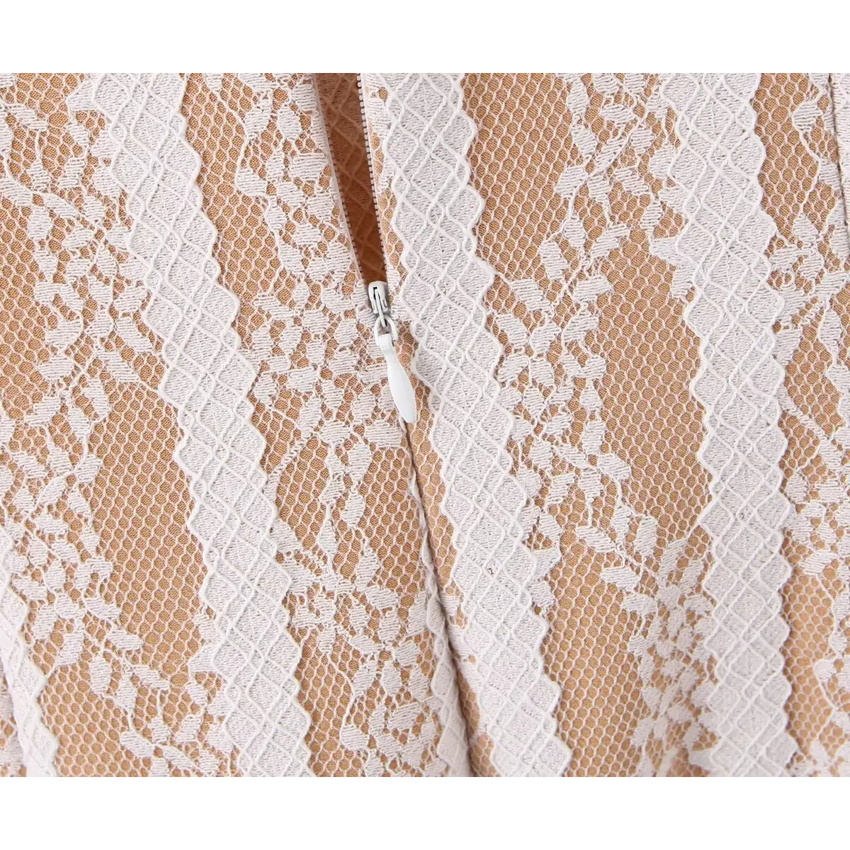 Close-up detail shot of the side zipper on a nude lace striped mini dress, showing the white zipper pull and lace pattern.