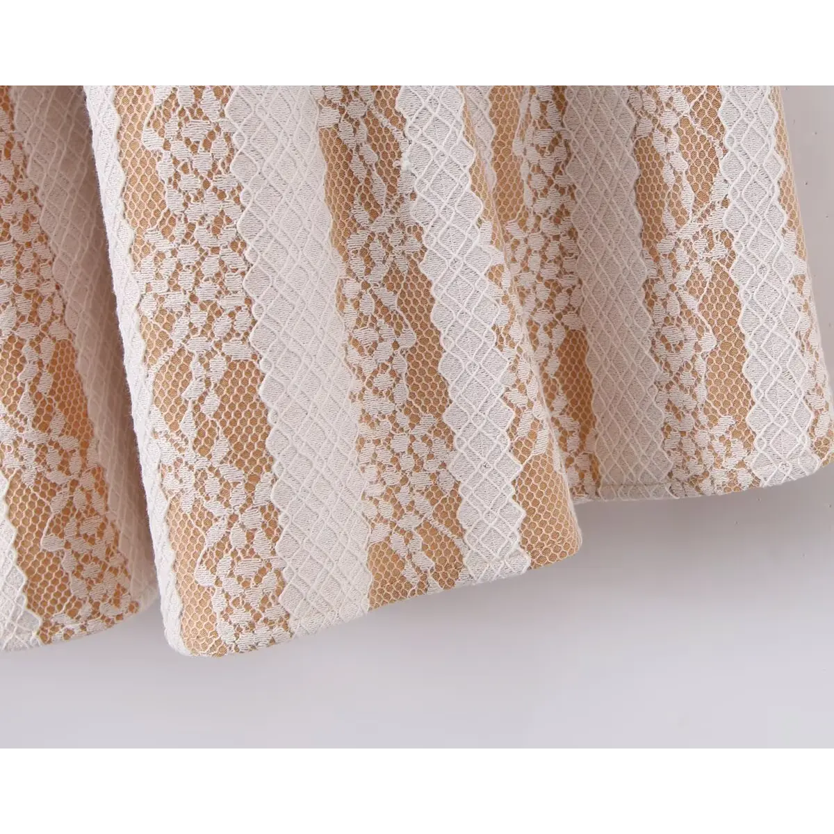  Close-up view of the skirt hem on a nude lace striped mini dress, showing the vertical floral lace pattern and flared silhouette.