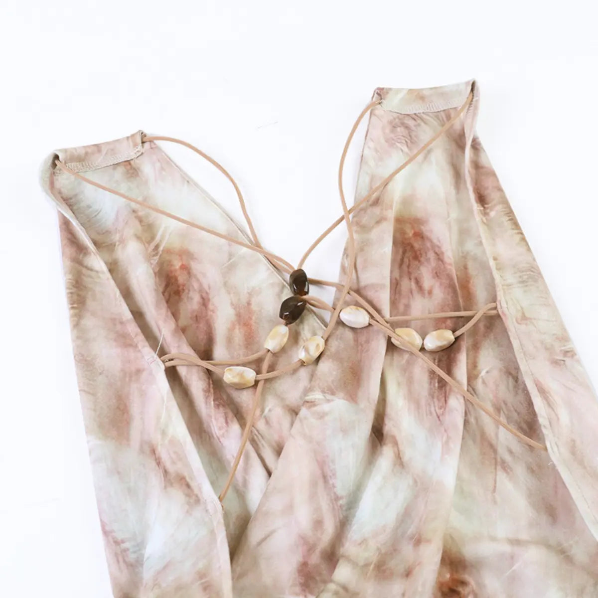 Close-up of the front straps on the nude tie-dye dress, showing the crisscross design and beaded accents
