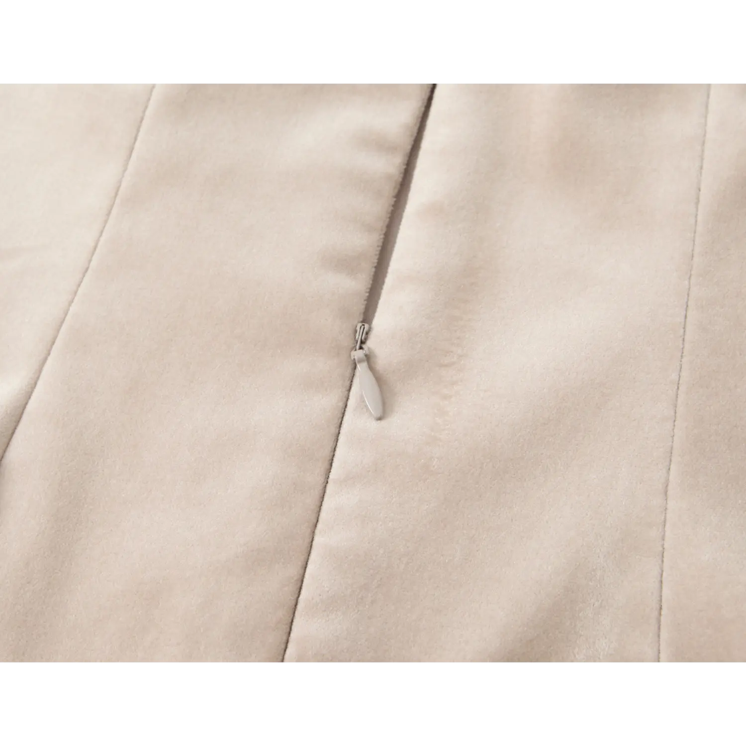Close-up matching nude coated invisible zipper, small teardrop fabric pull tab, vertical corset seam meet horizontal waist gather seam