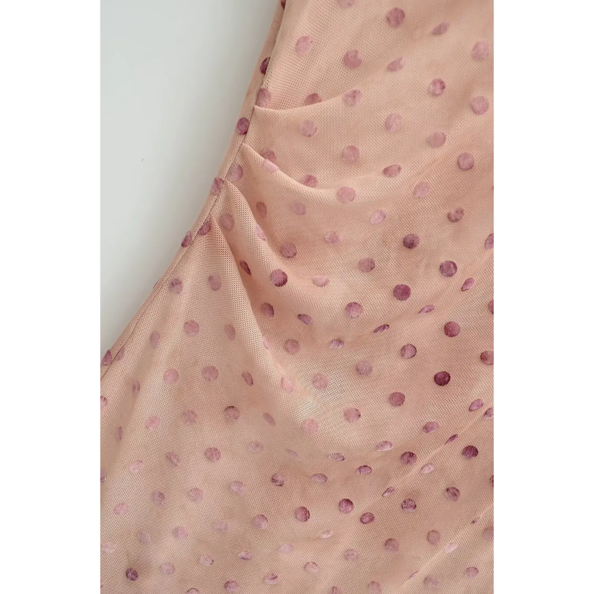 Close‑up of side waist ruched detail on nude pink polka dot maxi dress