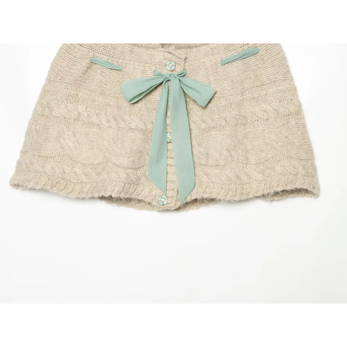 Lower front partial shot of oat cable knit skort, mint bow and flower buttons, cable knit texture