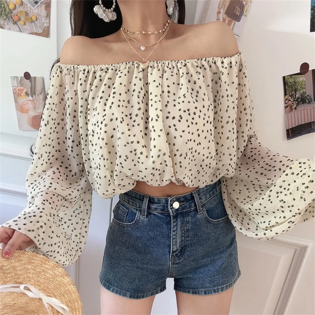Close-up view of the off-shoulder cream blouse with black dot print, showing the elasticated neckline and flowy sleeves
