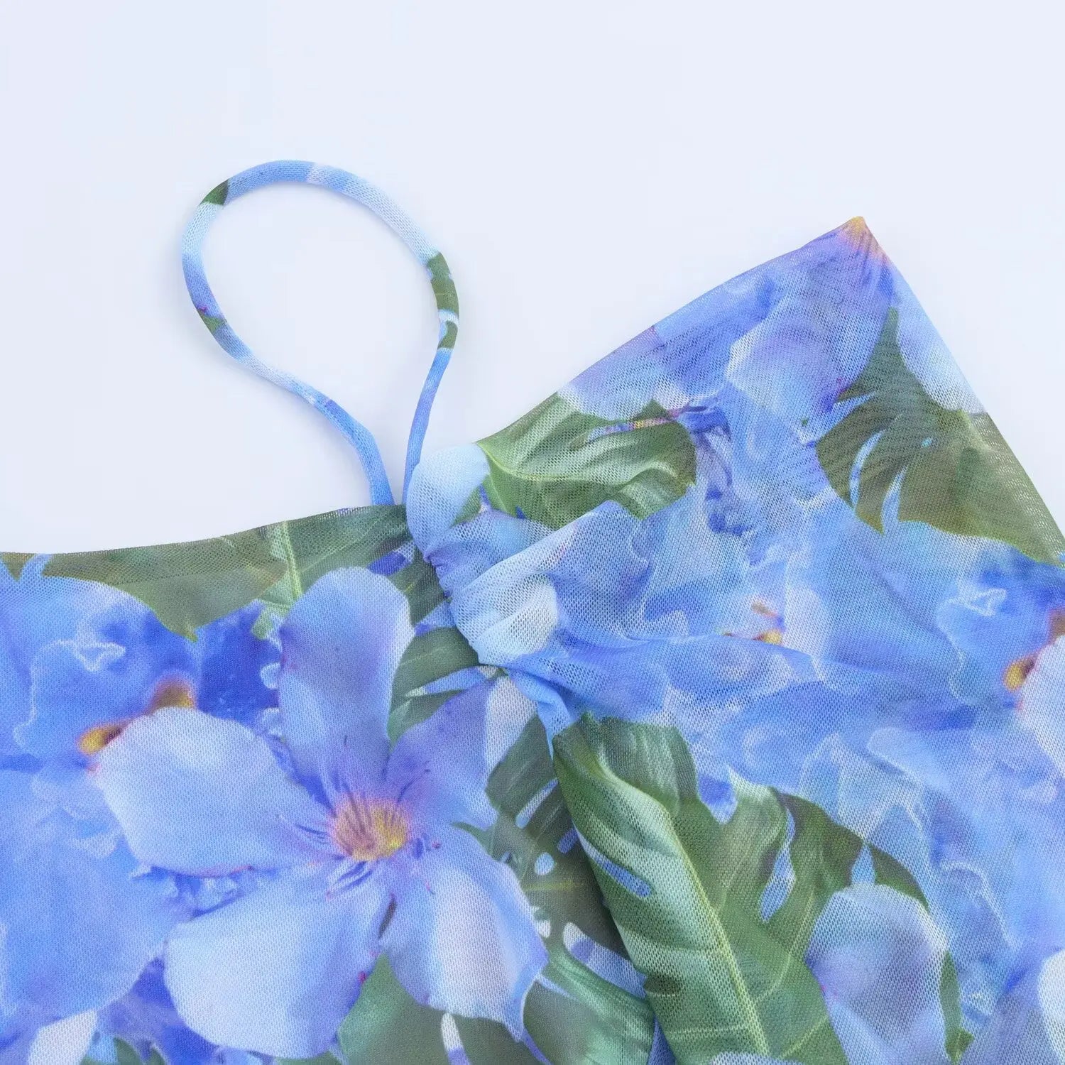 Close‑up of off‑shoulder sleeve construction, sheer mesh fabric with blue tropical floral print