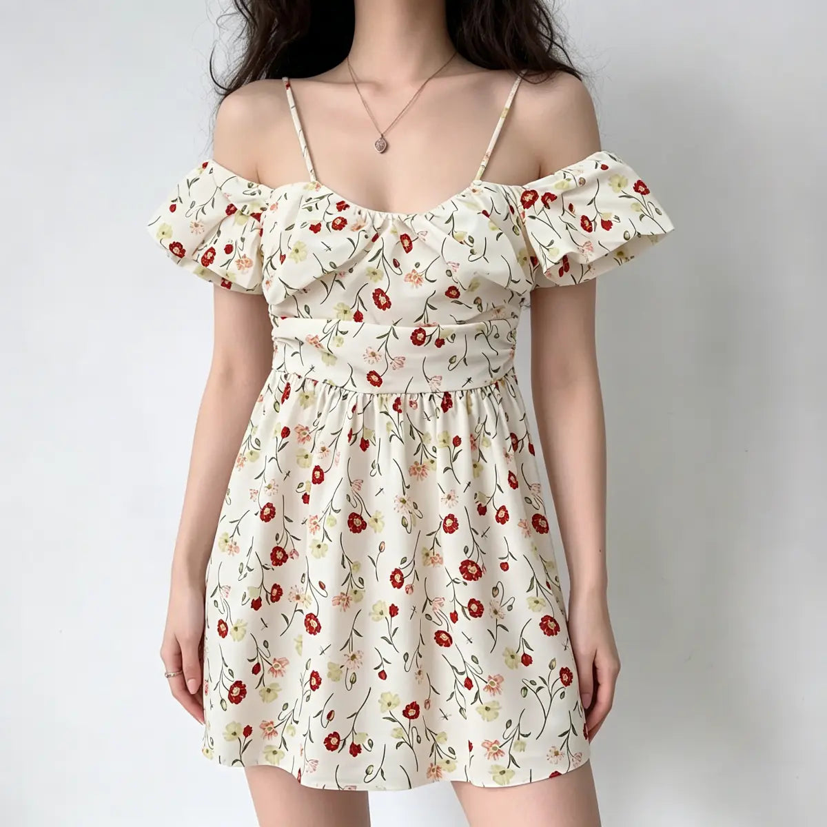 Full front view of a model wearing an off-shoulder poppy-print mini dress with spaghetti straps.
