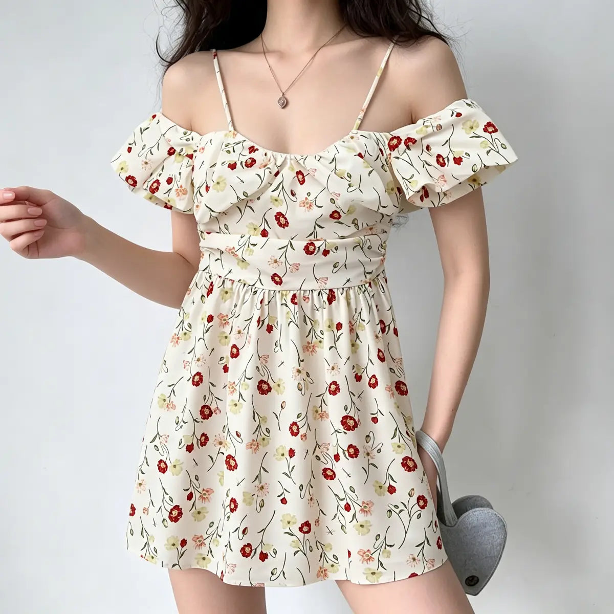Walking view of a model in an off-shoulder poppy-print mini dress, showing the dress flow.