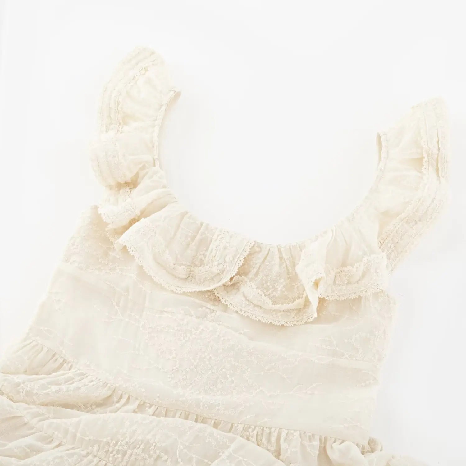 Off shoulder double ruffle lace trim neck macro close-up, layered shirred lace dense floral embroidery soft shoulder covering neck craft shot