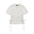 Full front flat‑lay shot of off‑white grid print embroidered short sleeve peplum top