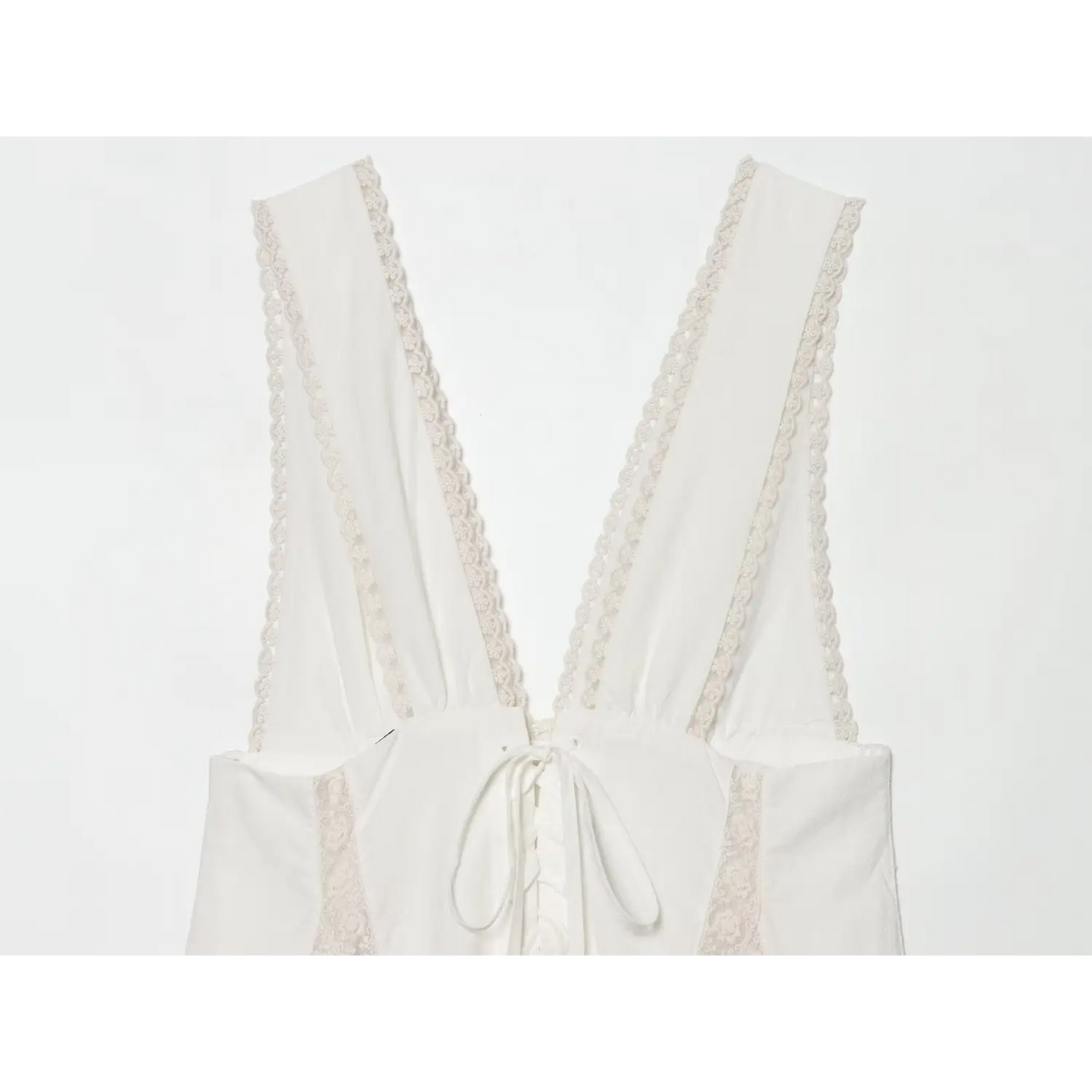 Close‑up of corset lace‑up back design of off‑white lace sleeveless mini dress