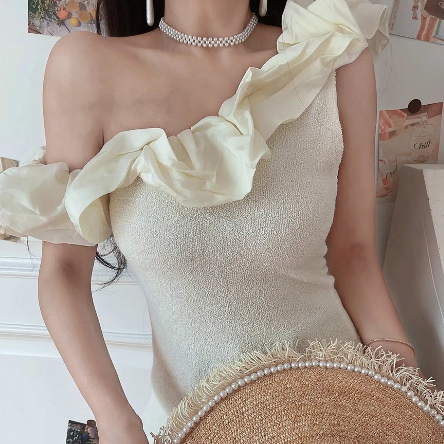 Women off white textured knit one shoulder crop top, 3d chiffon ruffle fitted waist, low angle partial indoor model photo