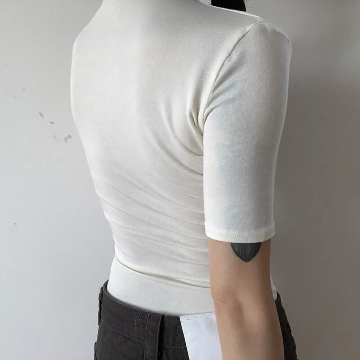 Back view detail shot of off-white ribbed half-turtleneck top, showing fit and fabric