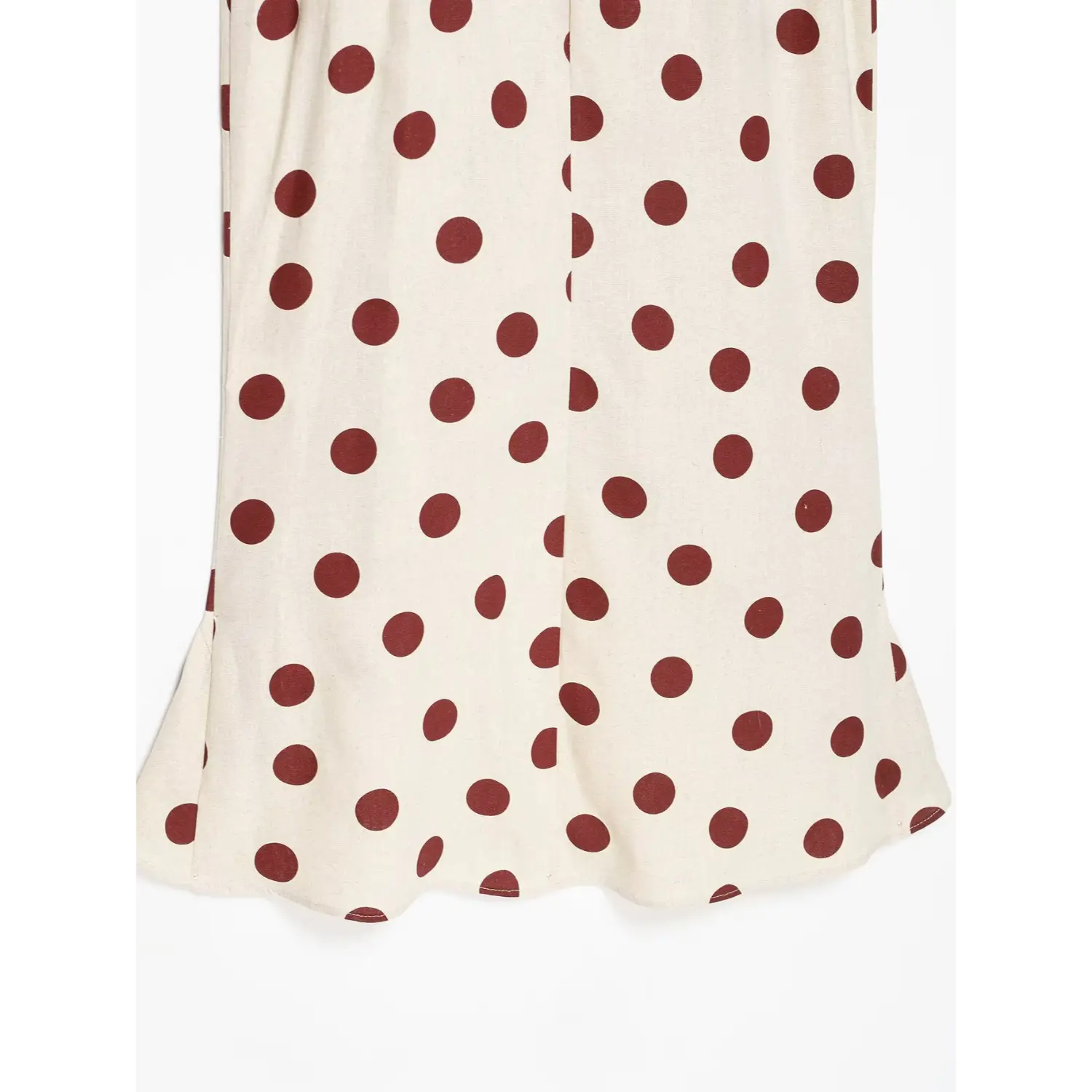 Flat close-up of back skirt hem and flared ruffle detail on polka dot linen midi dress