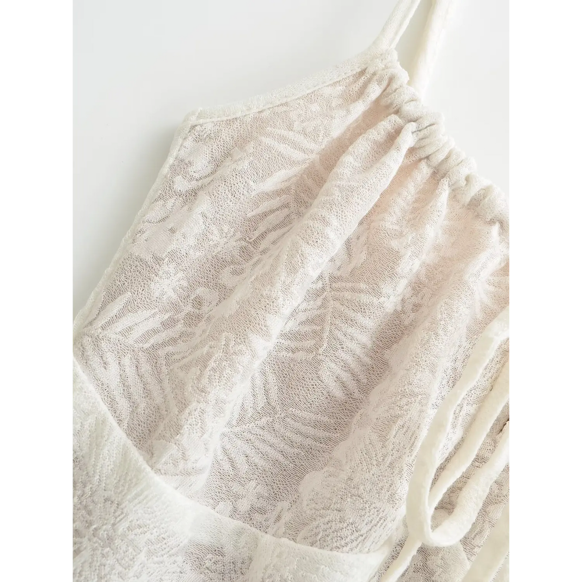 Close‑up of off white floral lace bust detail and thin shoulder straps