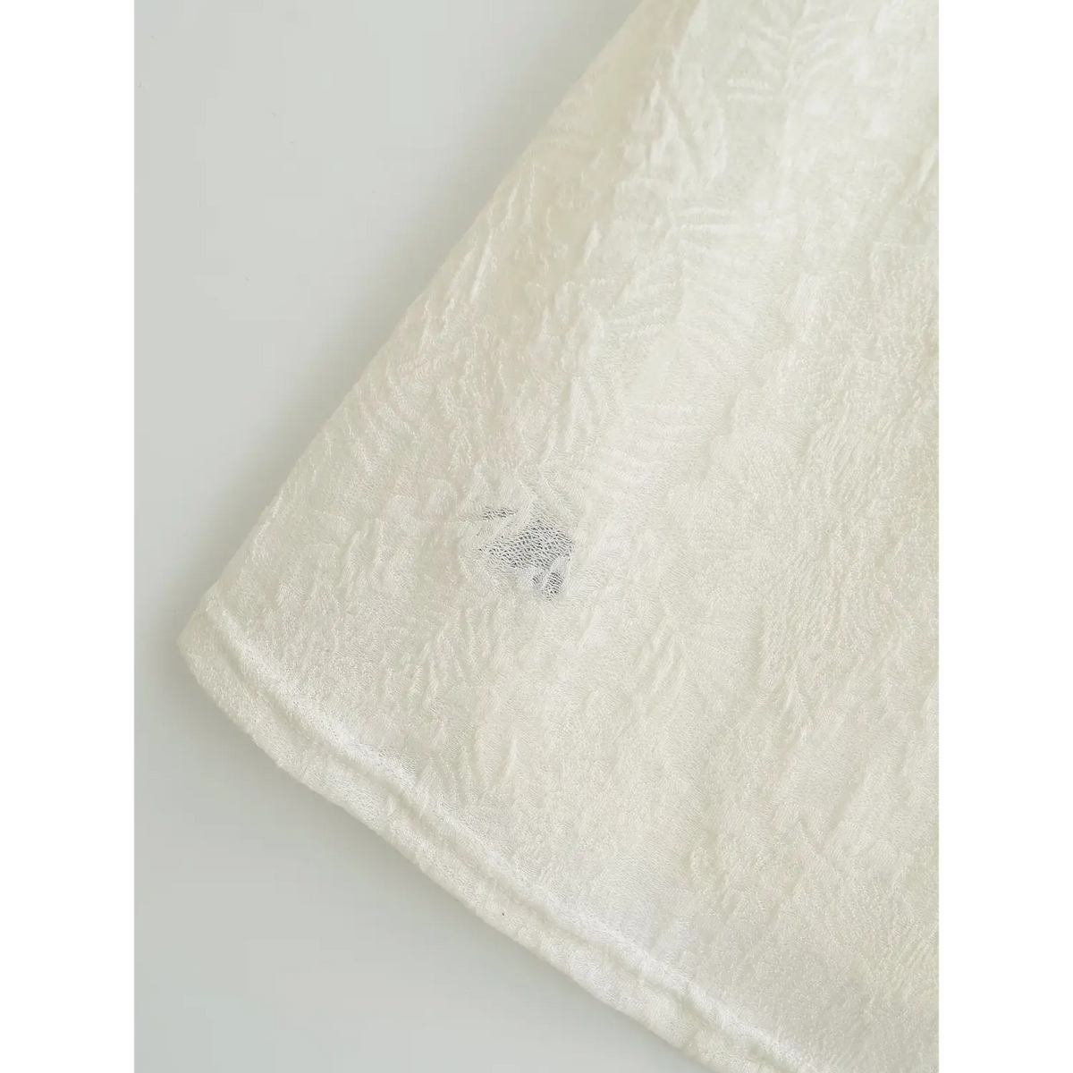 Close‑up of soft solid inner lining under off white lace overlay