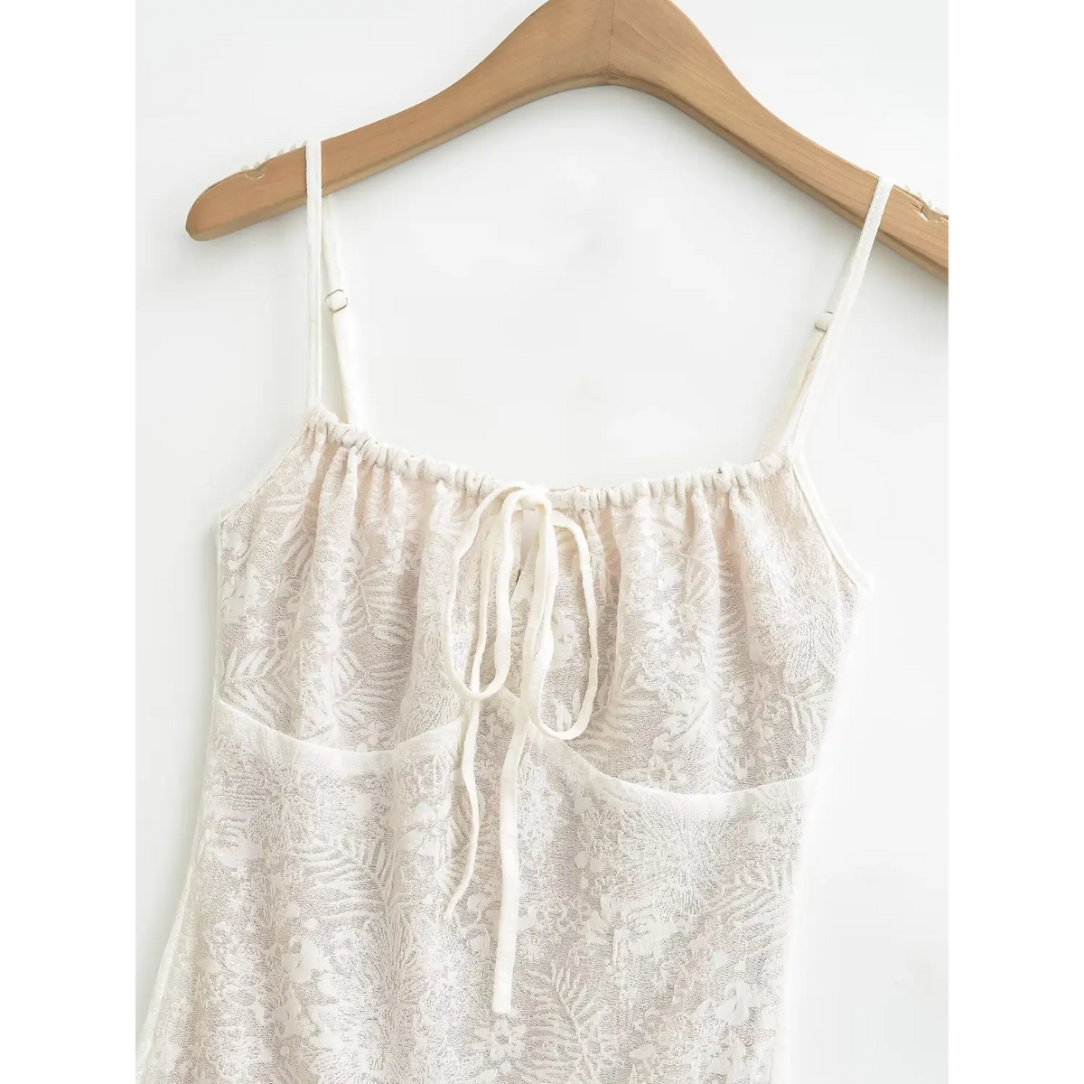 Close‑up of scalloped lace neckline and spaghetti strap detail