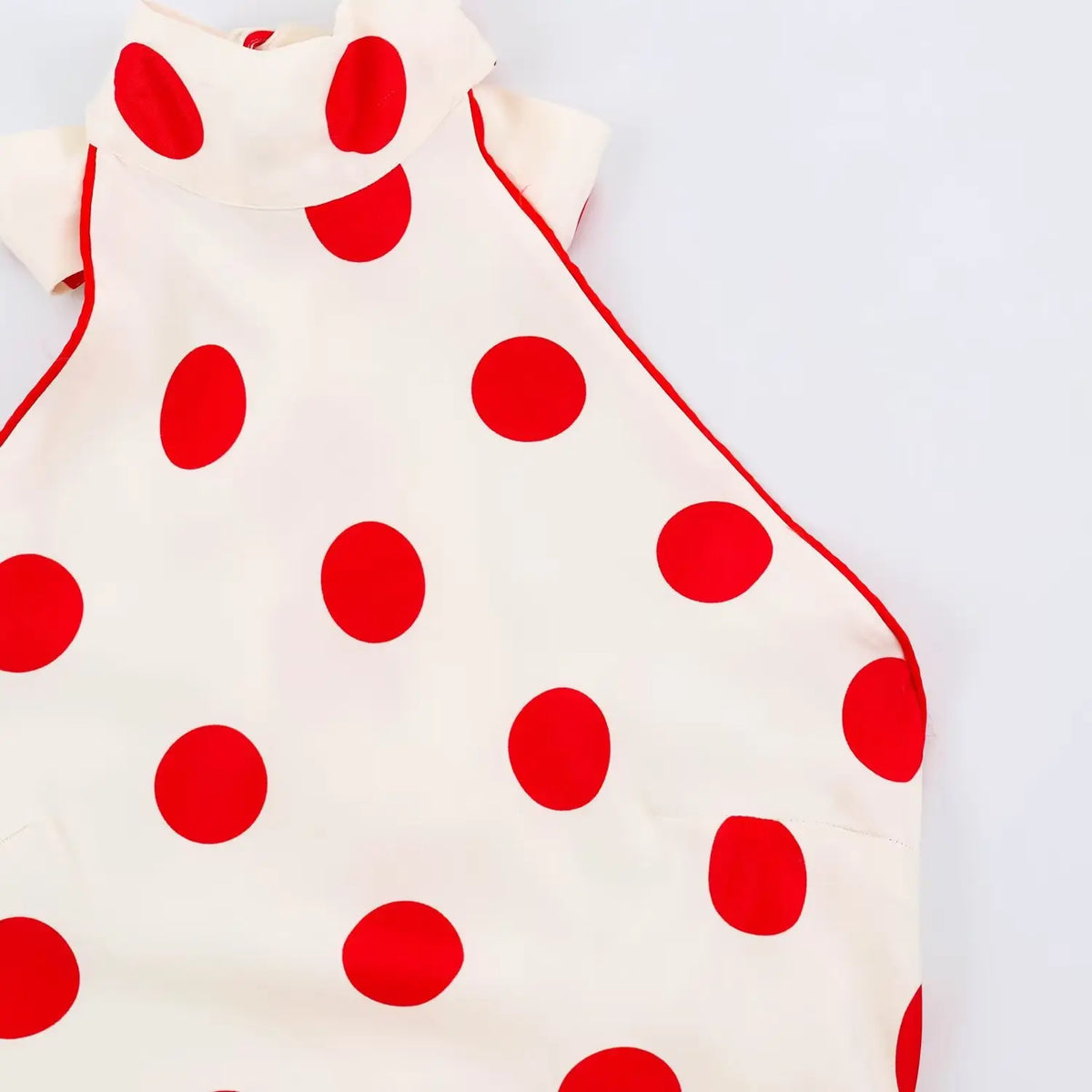 Close‑up of halter armhole and red piping edge detail