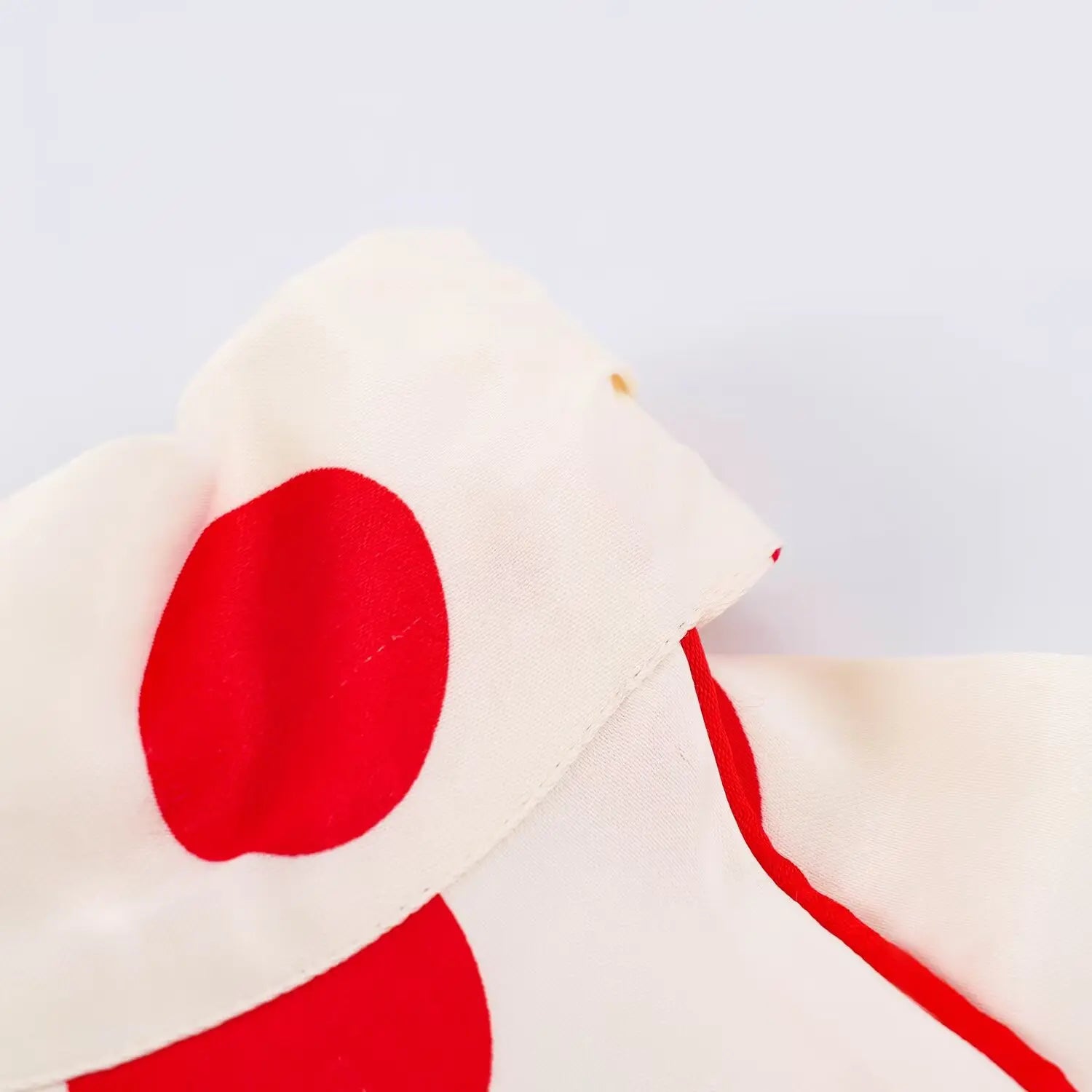 Close‑up of halter neck red piping trim and polka dot fabric