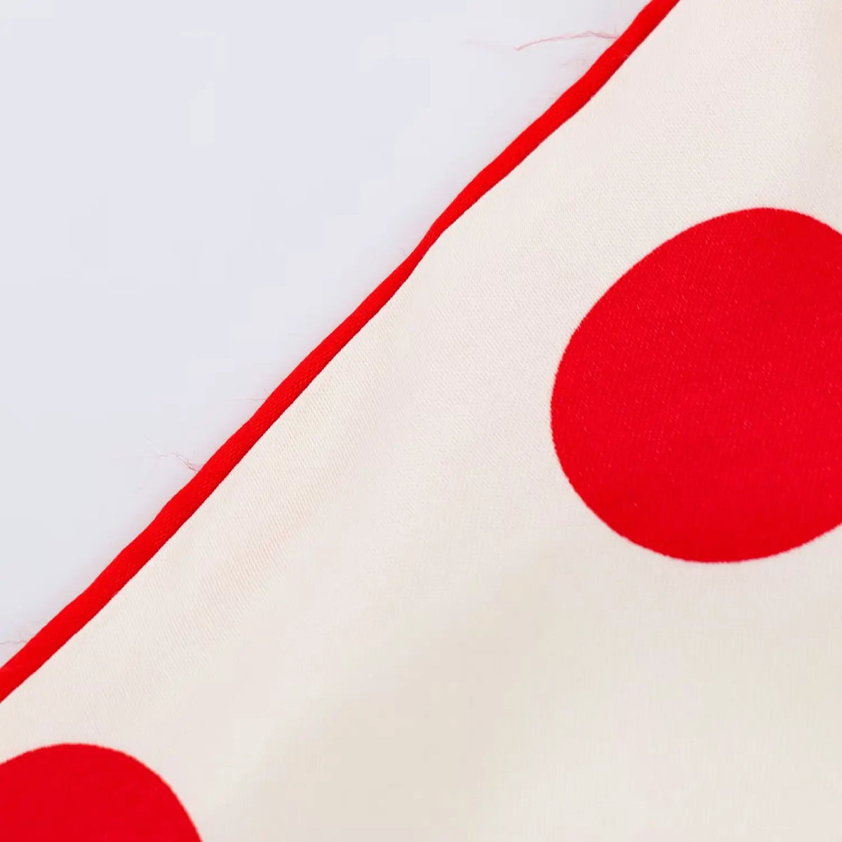 Macro close‑up of red piping trim and polka dot fabric texture