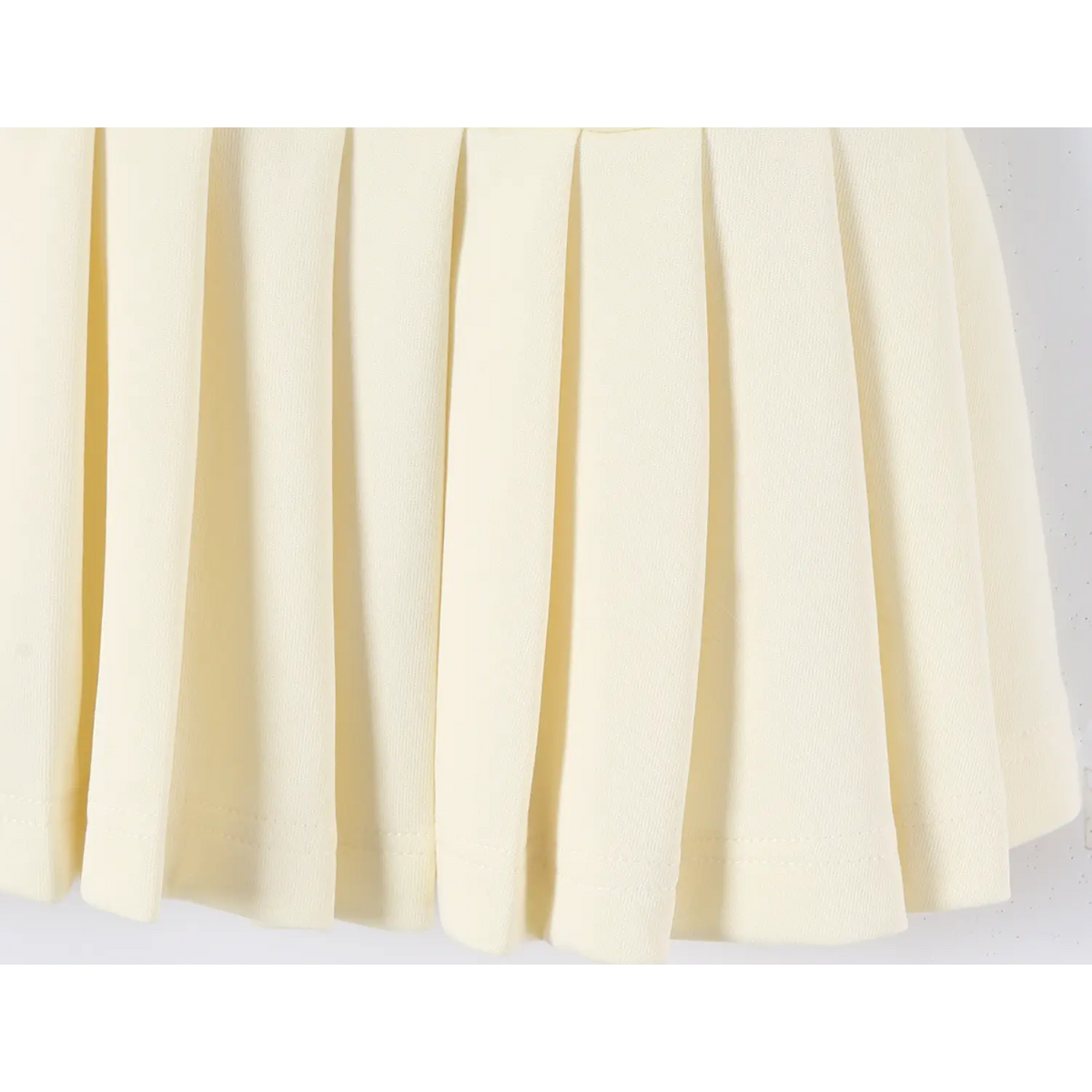 Close-up view of offwhite dress pleated skirt, neat knife pleats and hem stitching
