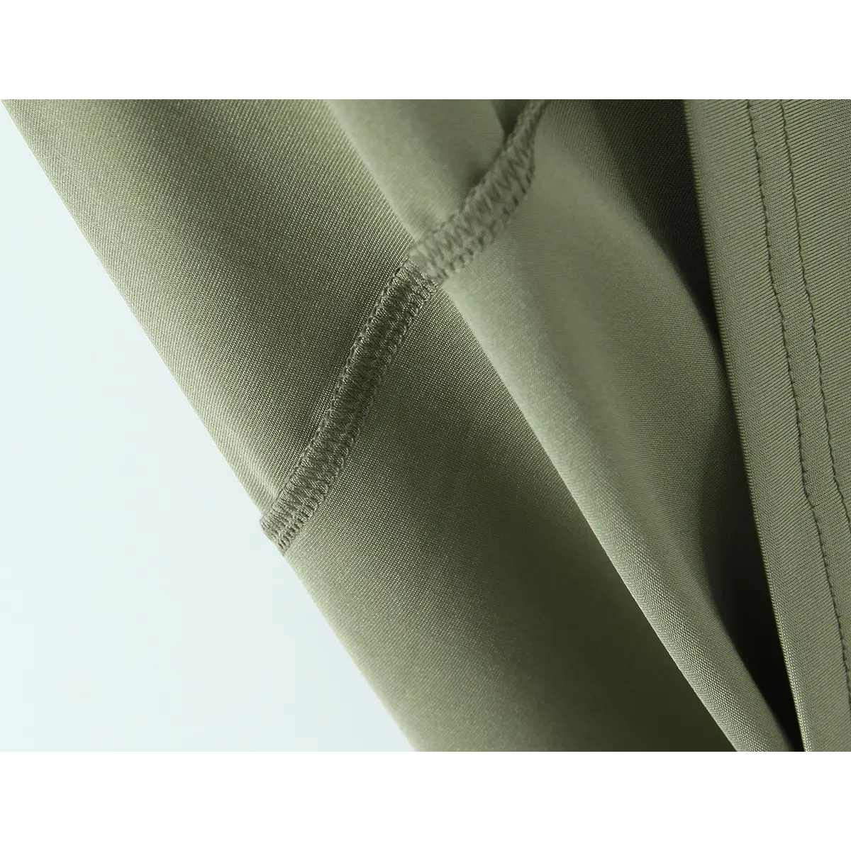 Close-up of the finished seam, showing the neat overlock stitching on the olive green fabric.