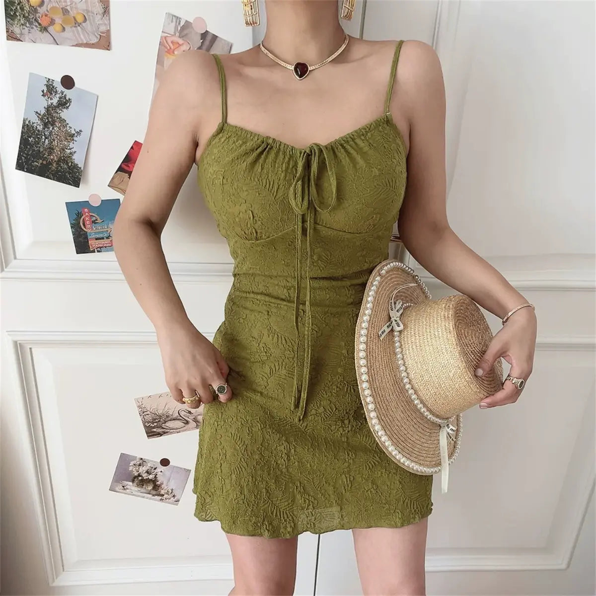 Form-fitting olive green embossed cami mini dress with front drawstring detail, worn by model