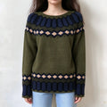 Female model wears olive green fairisle jumper, navy and light peach diamond jacquard motifs, crew neck casual knit top, front view