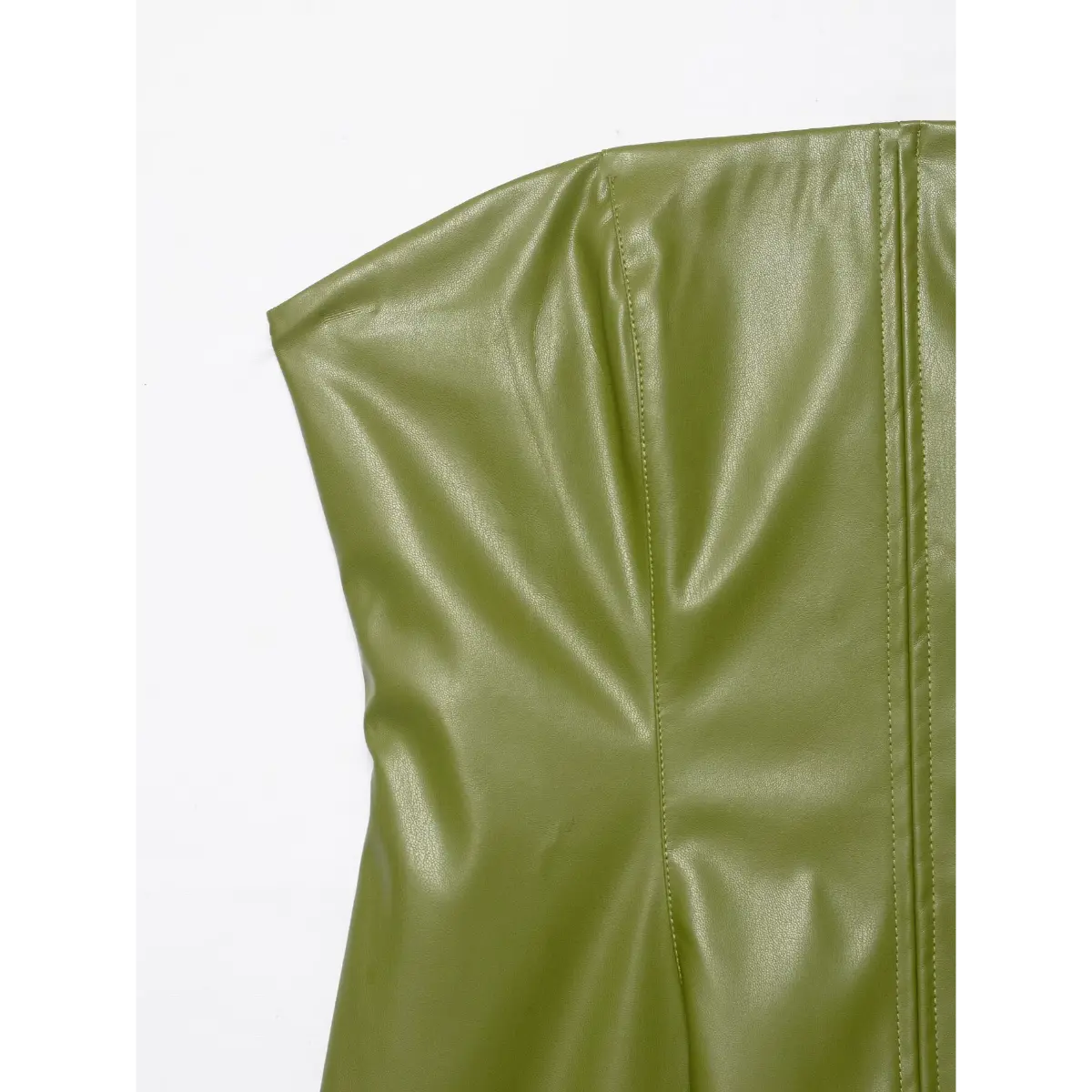 Close-up detail shot of the structured bodice on an olive green faux-leather strapless dress, highlighting the vertical seams and fabric texture.