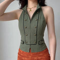 Female model wearing olive green halter vest, double breasted bronze buttons, black piping trim, paired with orange skirt, studio lifestyle shot