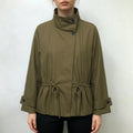 Model wearing olive green stand collar jacket with drawstring waist and black trousers
