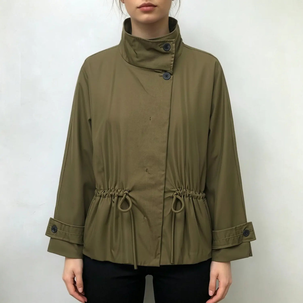 Model wearing olive green stand collar jacket with drawstring waist and black trousers