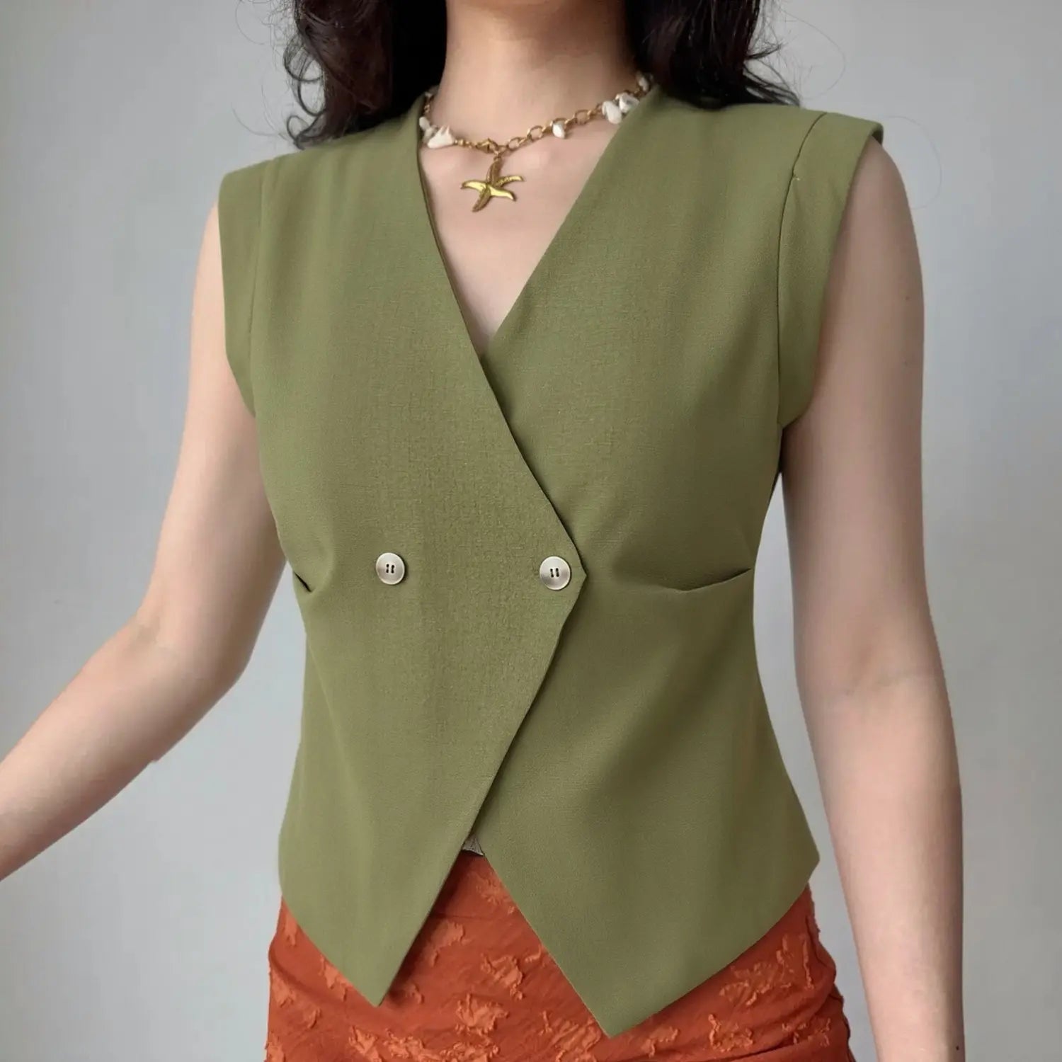 Front lifestyle shot on model, deep V double button slim waist vest, matched with orange textured bottoms, casual commuter layered outfit