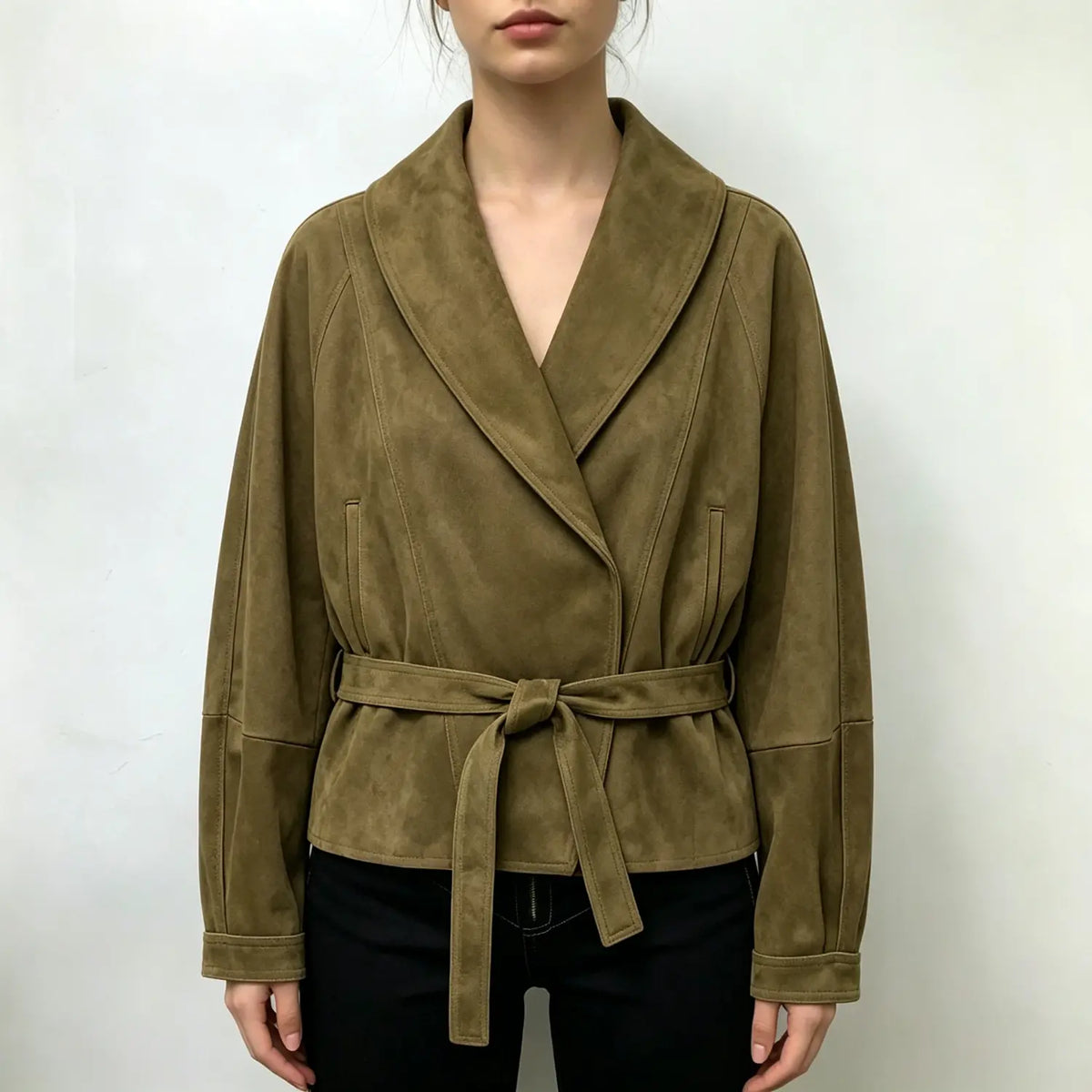 Model wearing olive suede wrap collar belted cropped jacket with black trousers