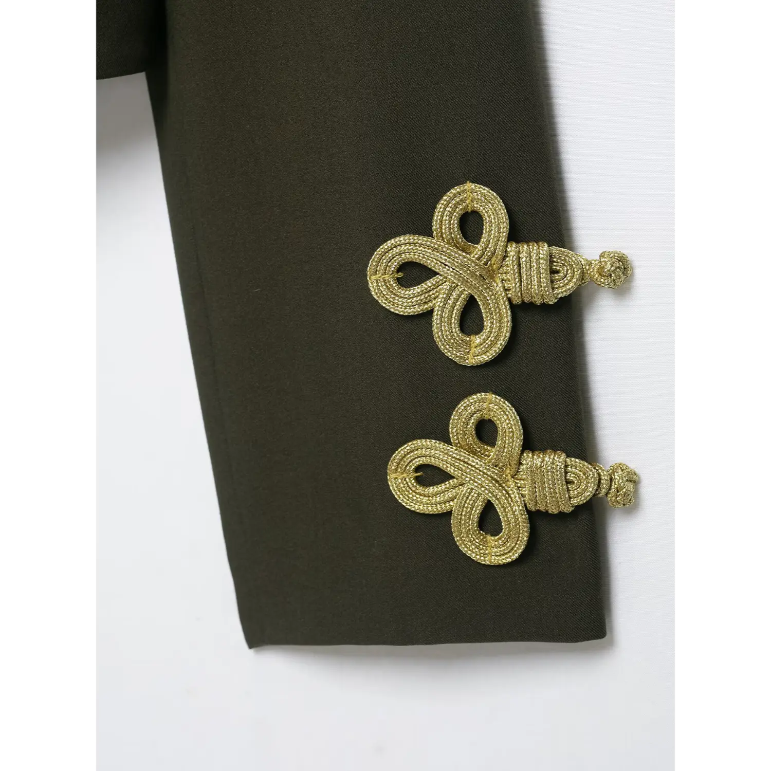 Close‑up view of decorative gold cord knot details on sleeve cuff of olive green cropped military blazer