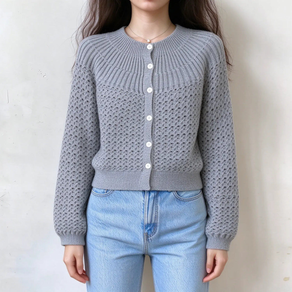 Model wearing openwork knit round neck button cardigan in gray, front view