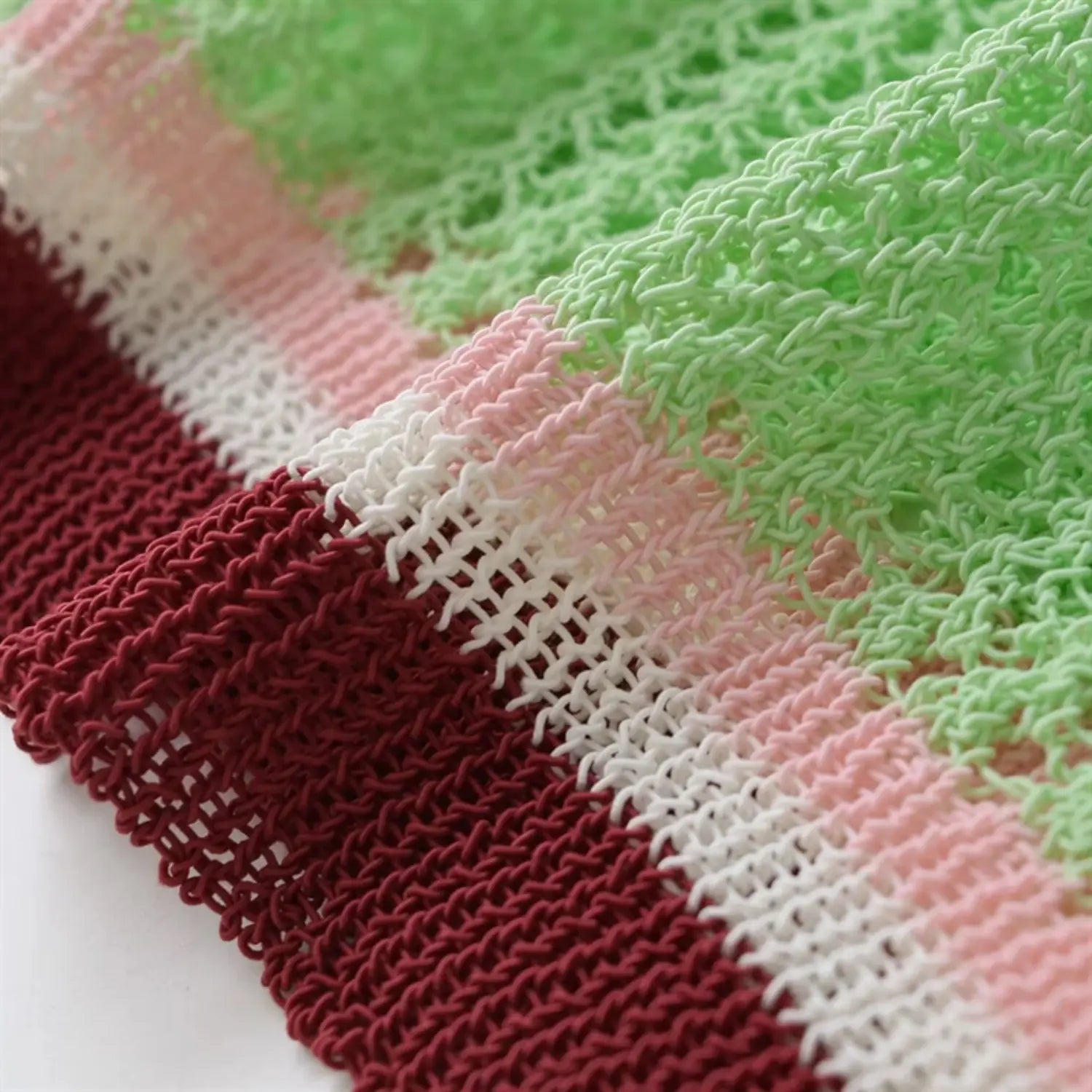 Fabric macro shot, light mint green openwork mesh knit, natural folds, breathable summer knit texture