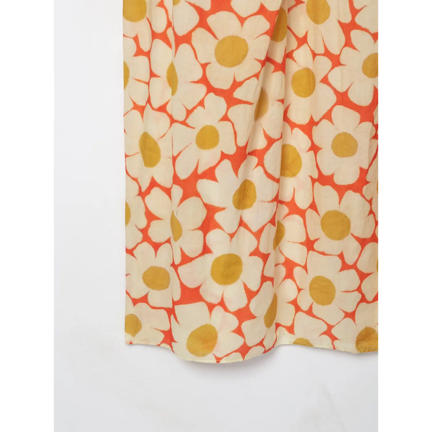 Close‑up of bottom hem fabric on orange daisy floral maxi dress