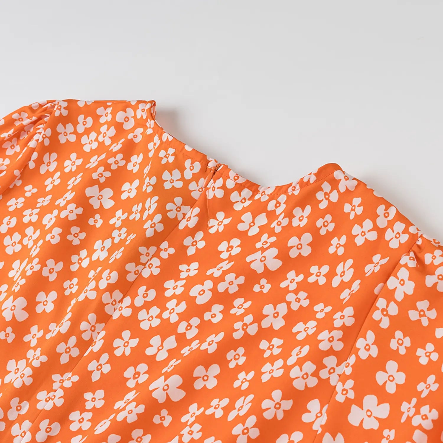 Close-up of the back neckline and invisible zipper on the orange floral dress