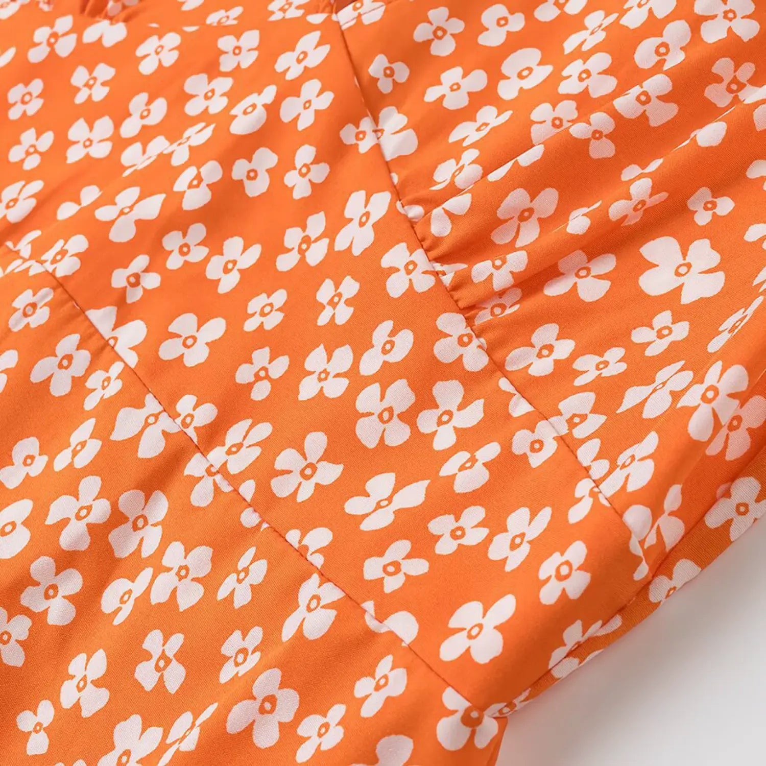 Close-up of the gathered stitching at the bustline of the orange floral dress
